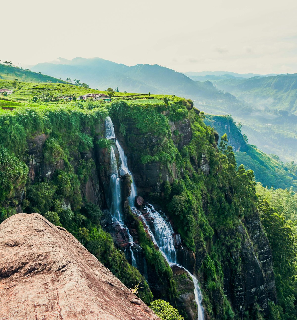 A tall waterfall falling through dense jungle in central Sri Lanka